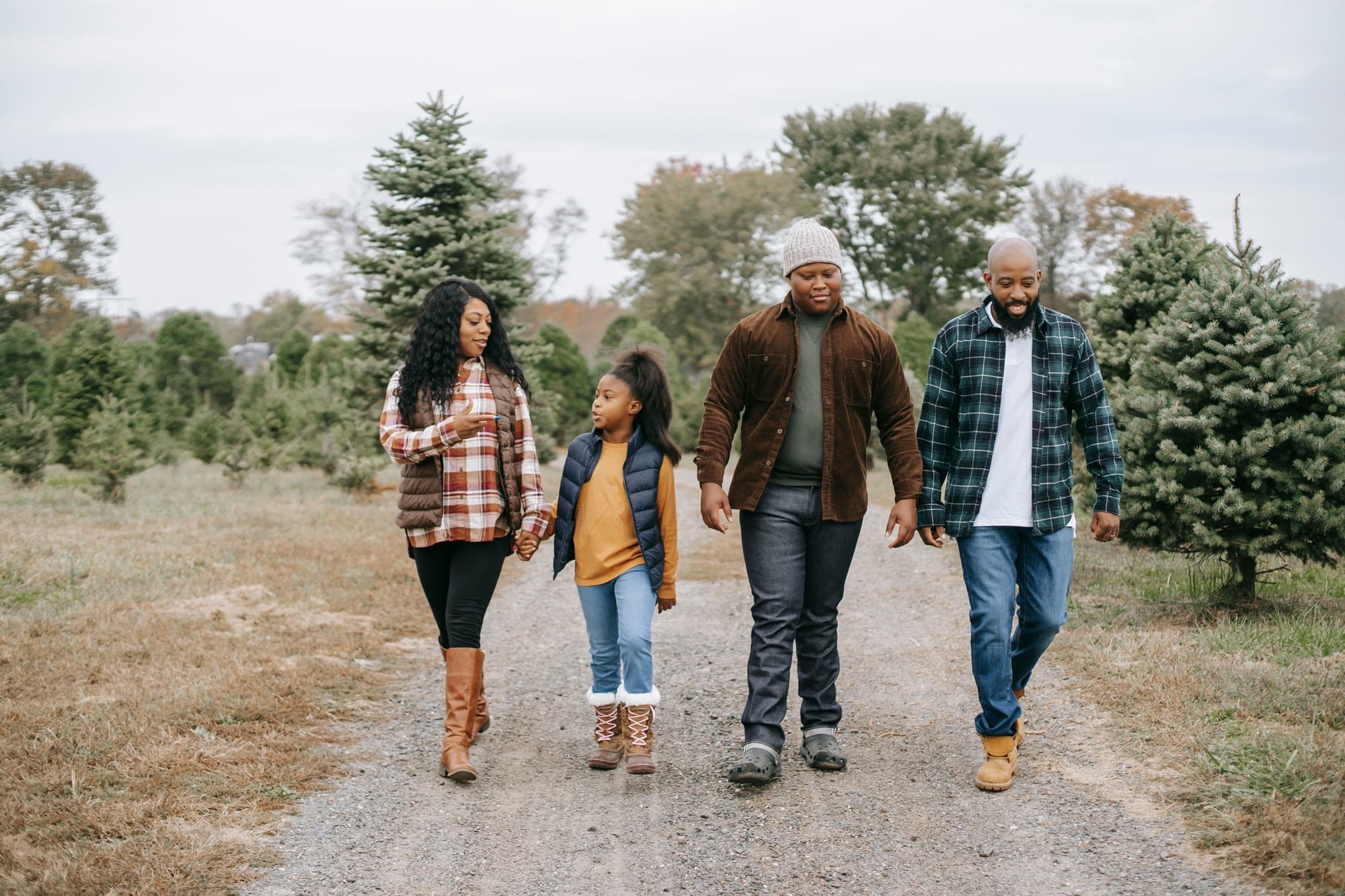 A family walking together hand in hand along a path, talking and smiling